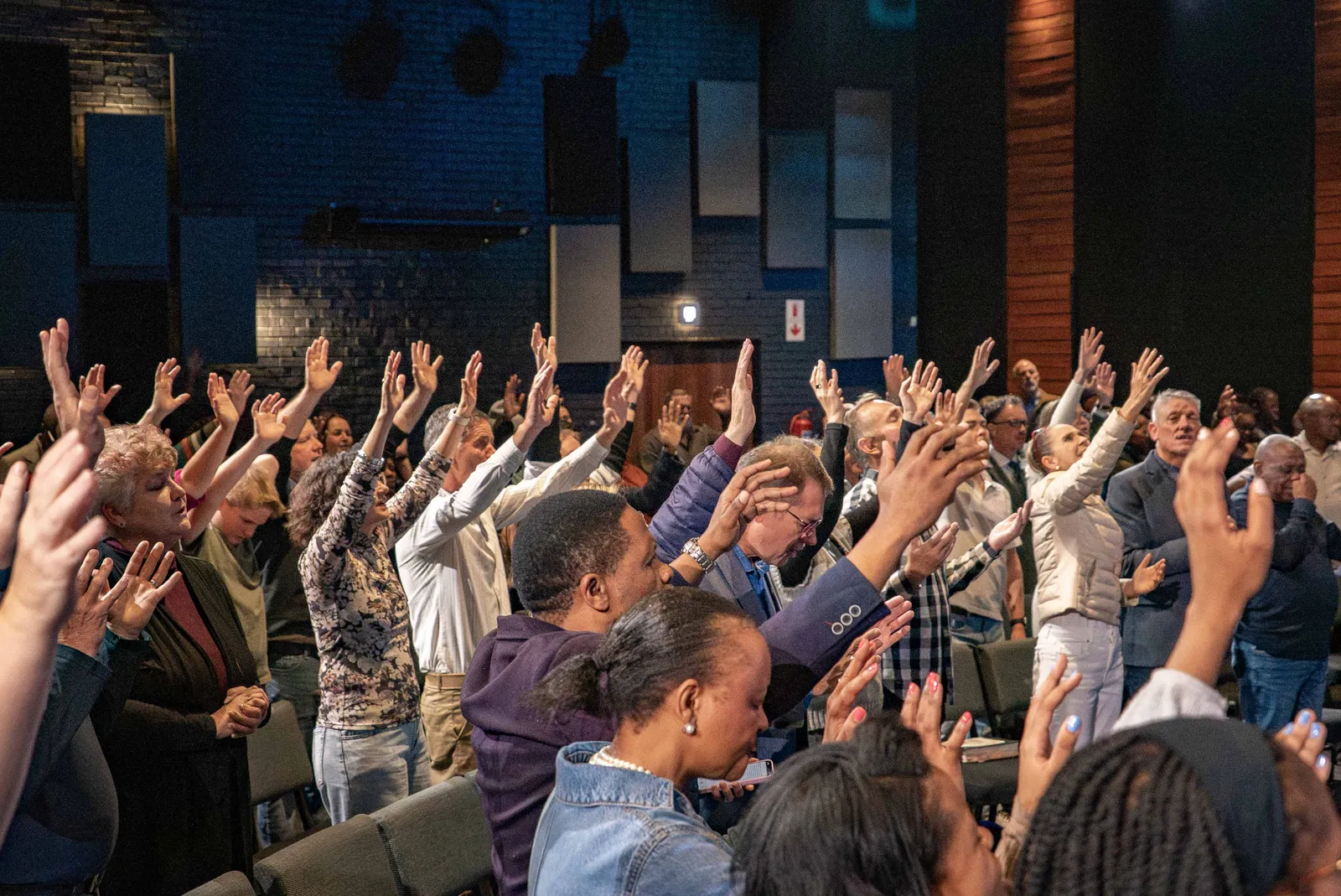 The family gathered, congregation standing in worship